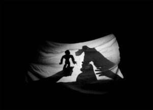 kids play shadow puppets with sheets