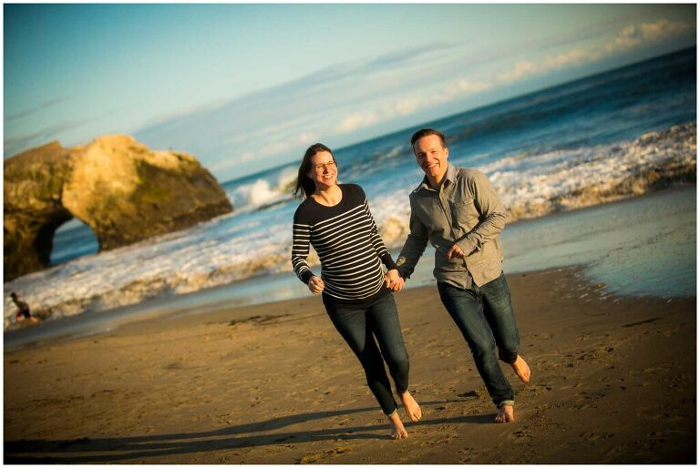 maternity portrait of couple running on beach in santa cruz, ca