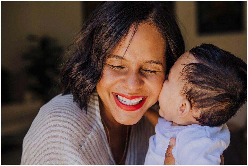 baby kisses his mom in the baby area for portrait session