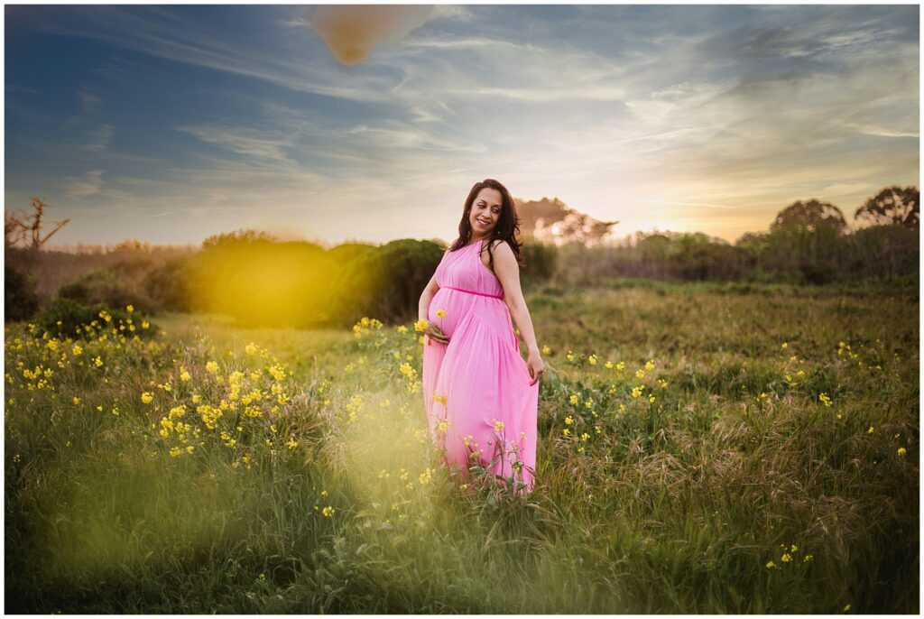 pregnant woman poses on Half Moon Bay beach for maternity photos