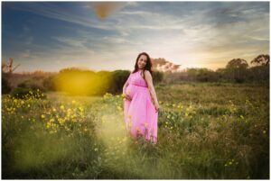 pregnant woman poses on Half Moon Bay beach for maternity photos