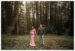 pregnant woman stands in redwoods in oakland for maternity pictures