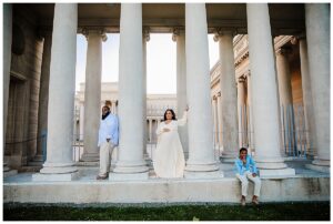 family with pregnant mother poses in front of Legion of Honor in San Francisco
