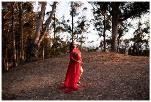 woman in red gown at maternity session in the bay area