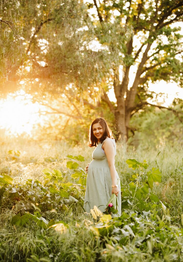 pregnant woman poses in wildflower field during maternity photo session