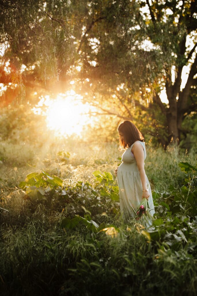pregnant woman poses in wildflower field during maternity photo session