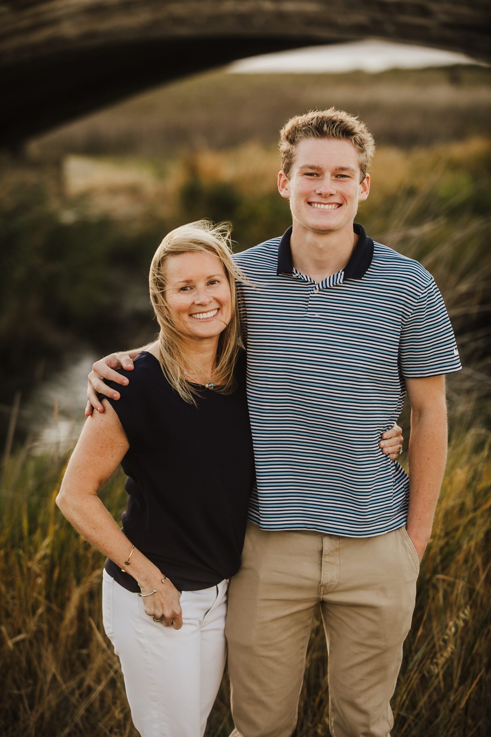 St. Louis family photographer, mother and her tall teenage son smiling together in tall coastal grass