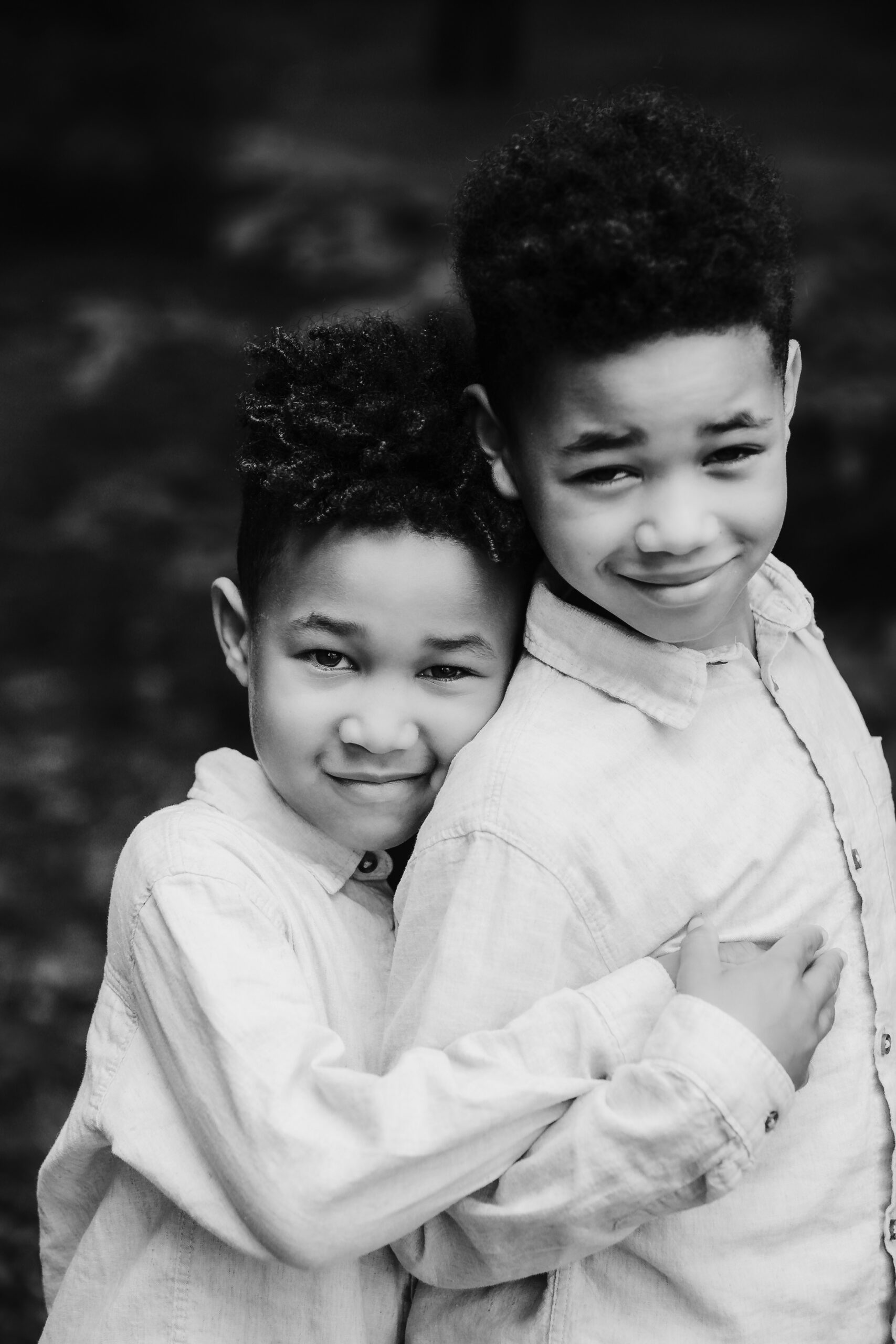 St. Louis family photographer, black and white portrait of two brothers hugging and smiling at the camera